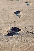 Barfußspuren im Sand die geradeaus führen