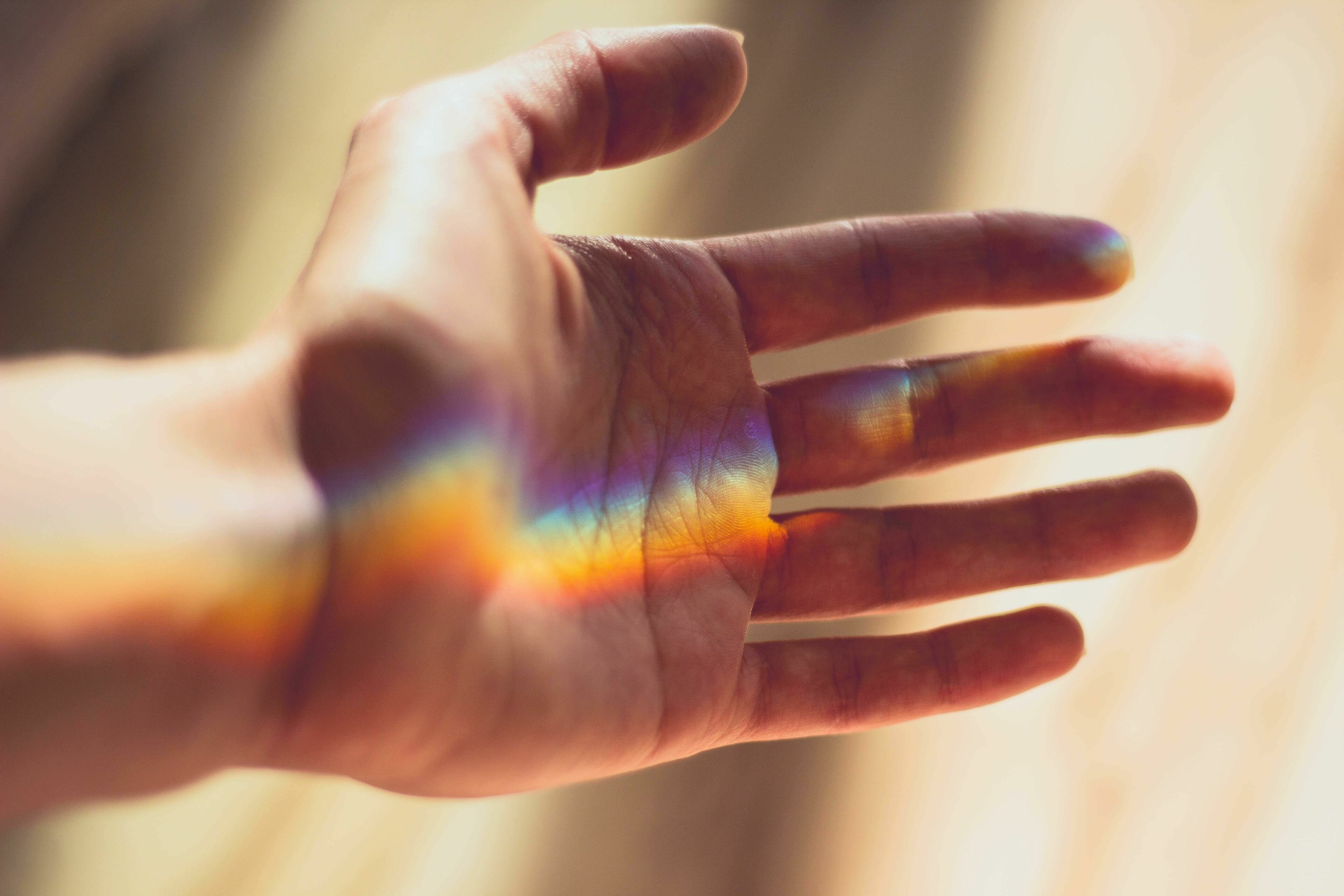 In einer Handfläche ist eine Regenbogen-Spiegelung zu sehen
