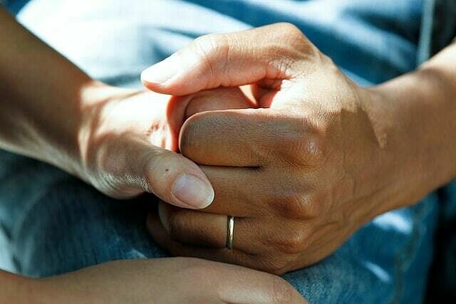 Die Hand eines vermeintlichen Patienten wird von einer anderen Hand unterstützend gedrückt